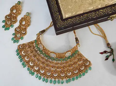 Temple design gold necklace set with pearl detailing and matching earrings